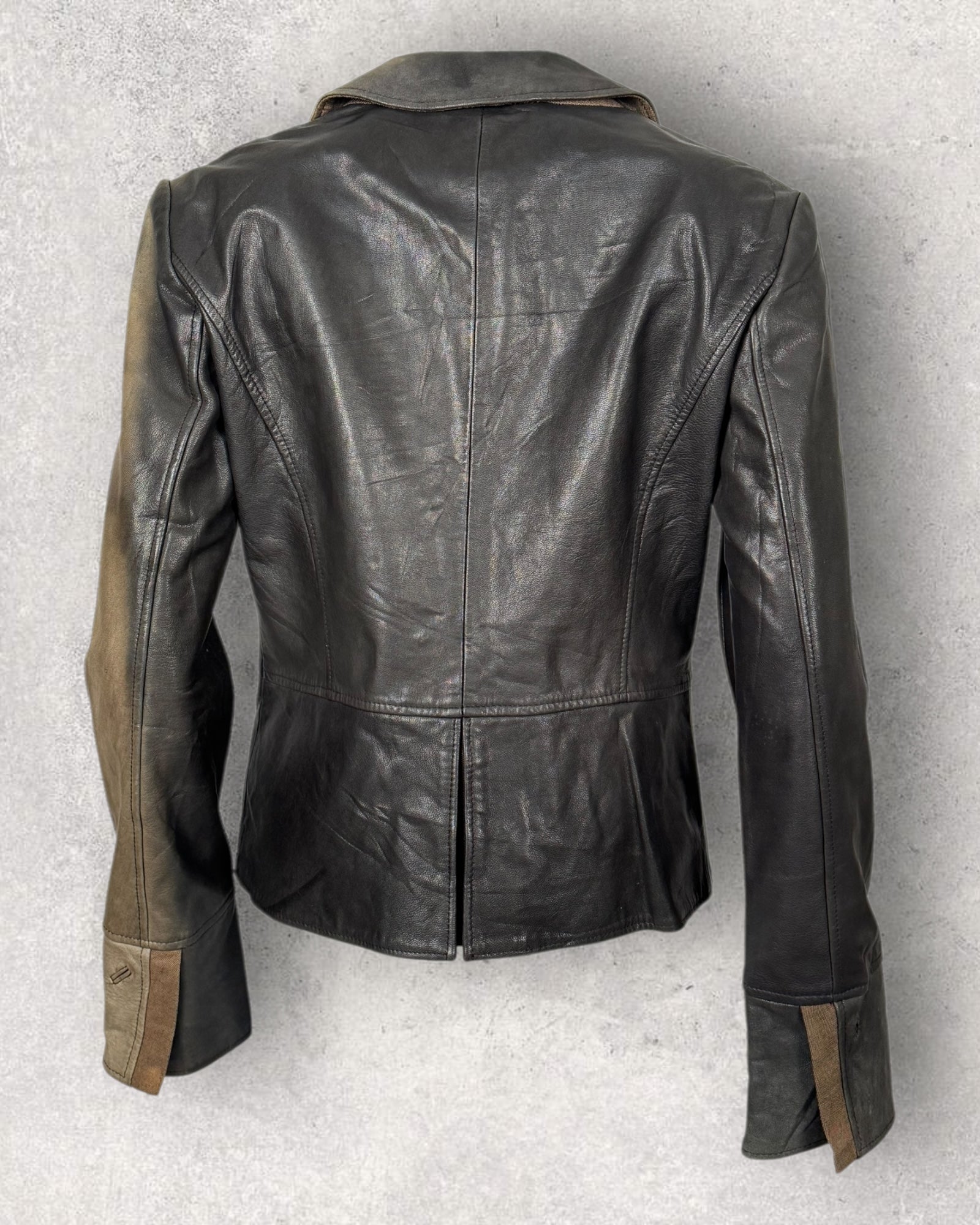 Black leather jacket with brown accents on a light gray background