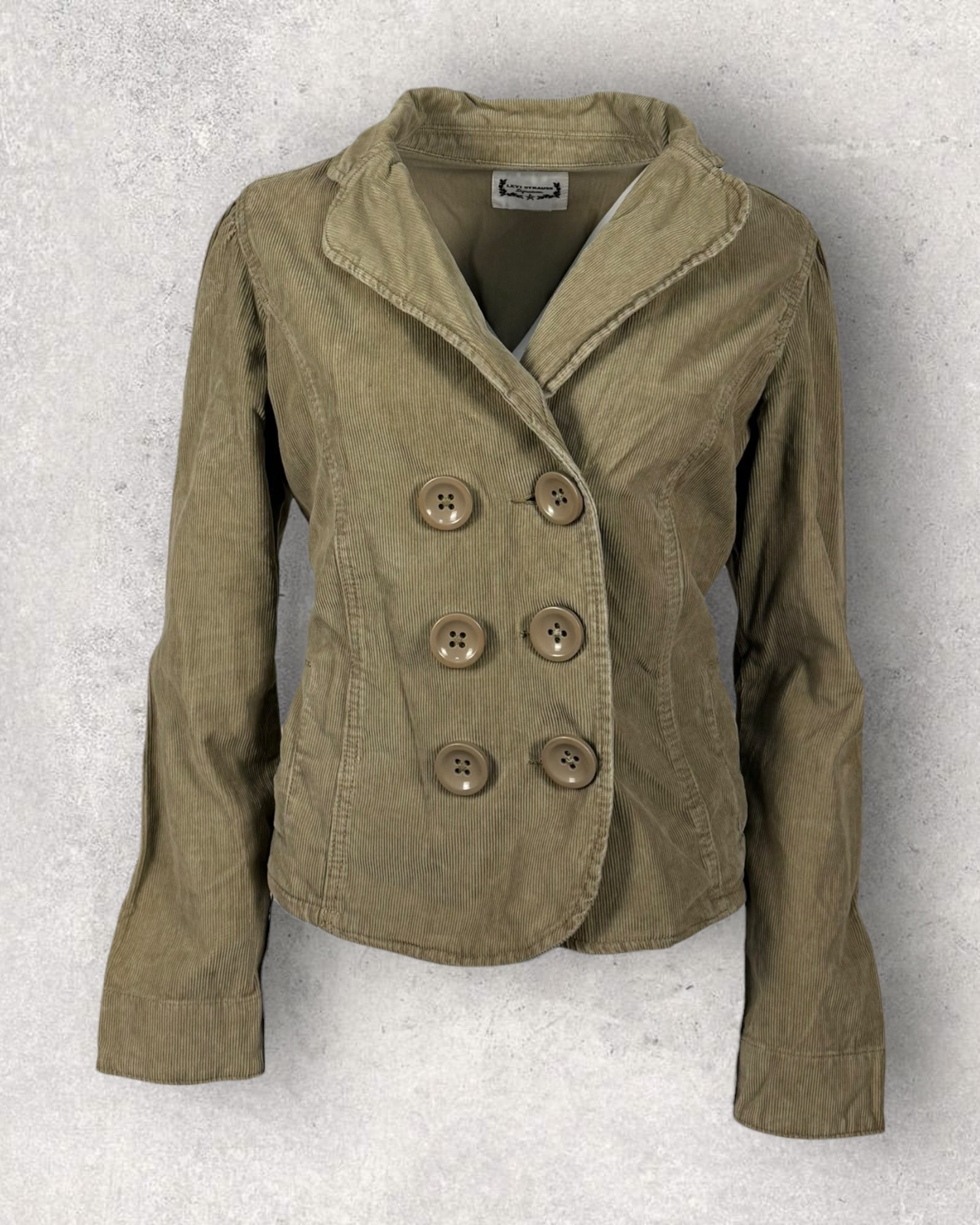 Corduroy jacket with button details on a textured gray background